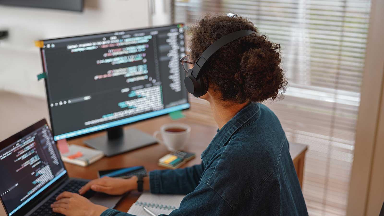 Student looking at code on two monitors representing Computer Science programs at Clarkson University